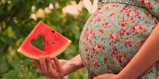 watermeloenplak in de hand van een zwangere vrouw